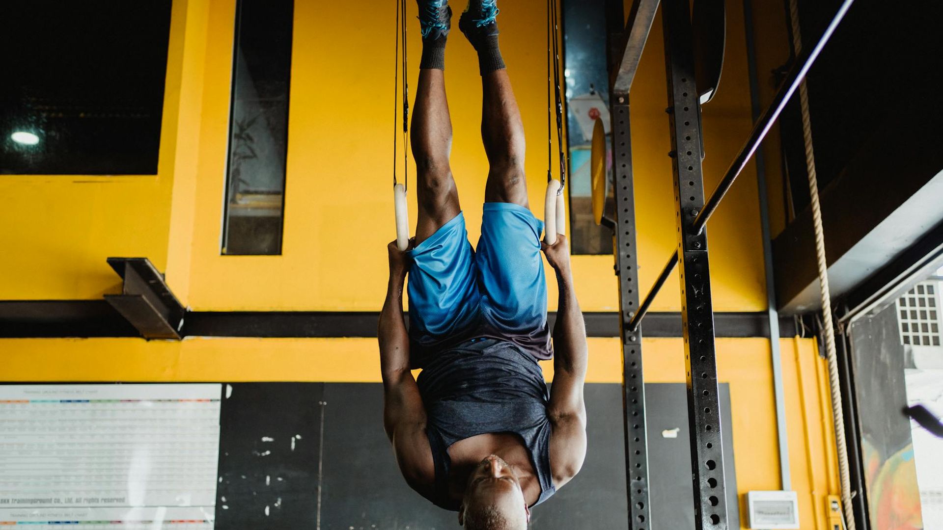 Man performing a controlled strength exercise in a minimalist gym.